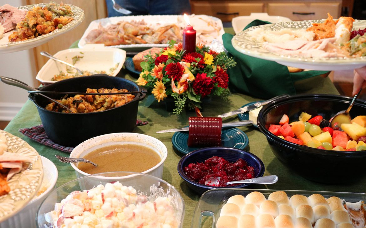 Casual Thanksgiving dinner table spread with multiple traditional dishes
