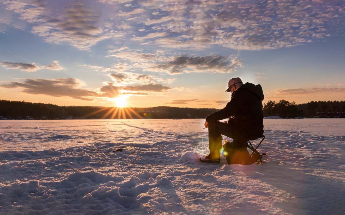 Man fishing on vast expanse of ice