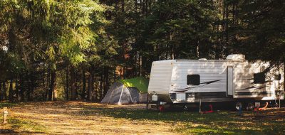 Travel trailer camped out in the woods.