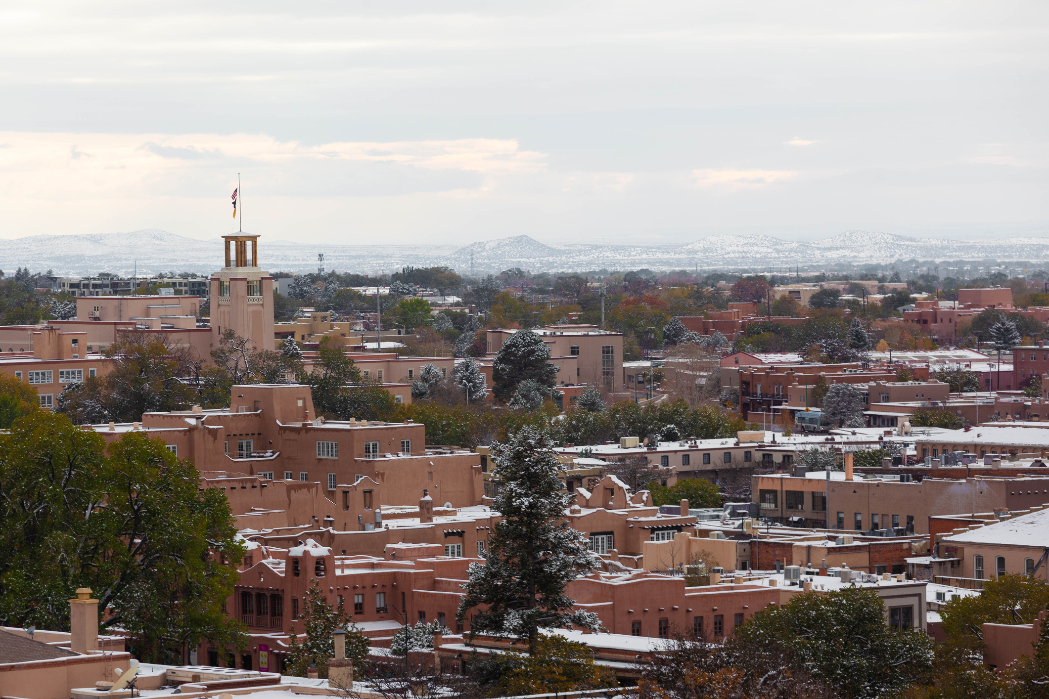 Snow covers the rooftops of adobe buildings