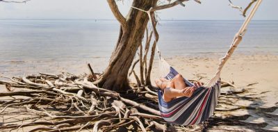 Woman relaxing on hammock in the beach.