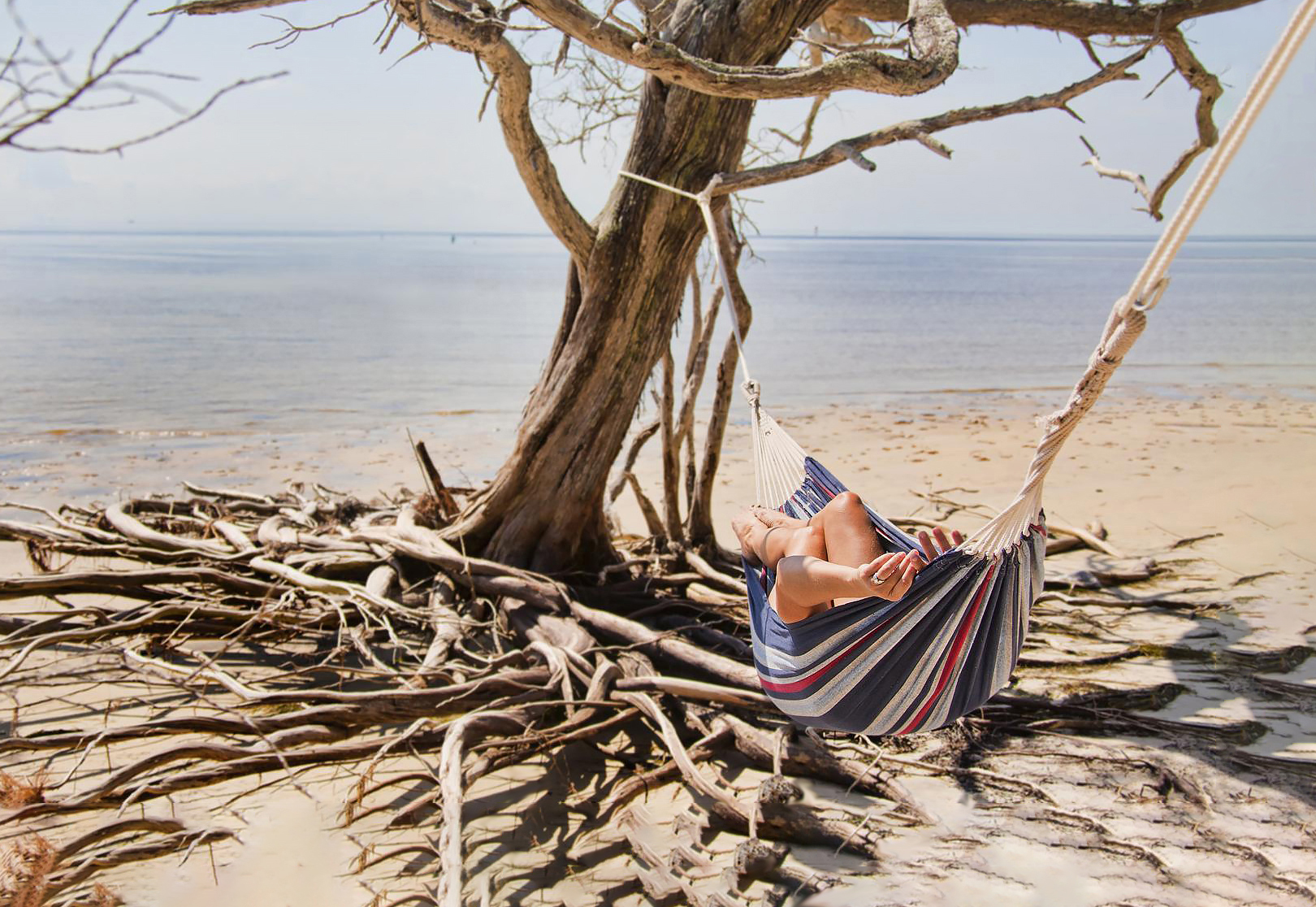Woman relaxing on hammock in the beach.