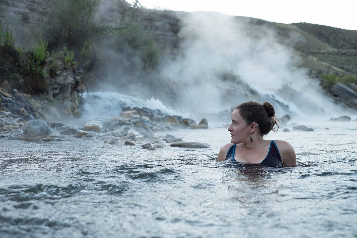A young woman enjoys a nice dip in a steamy river, the Boiling River in Montana