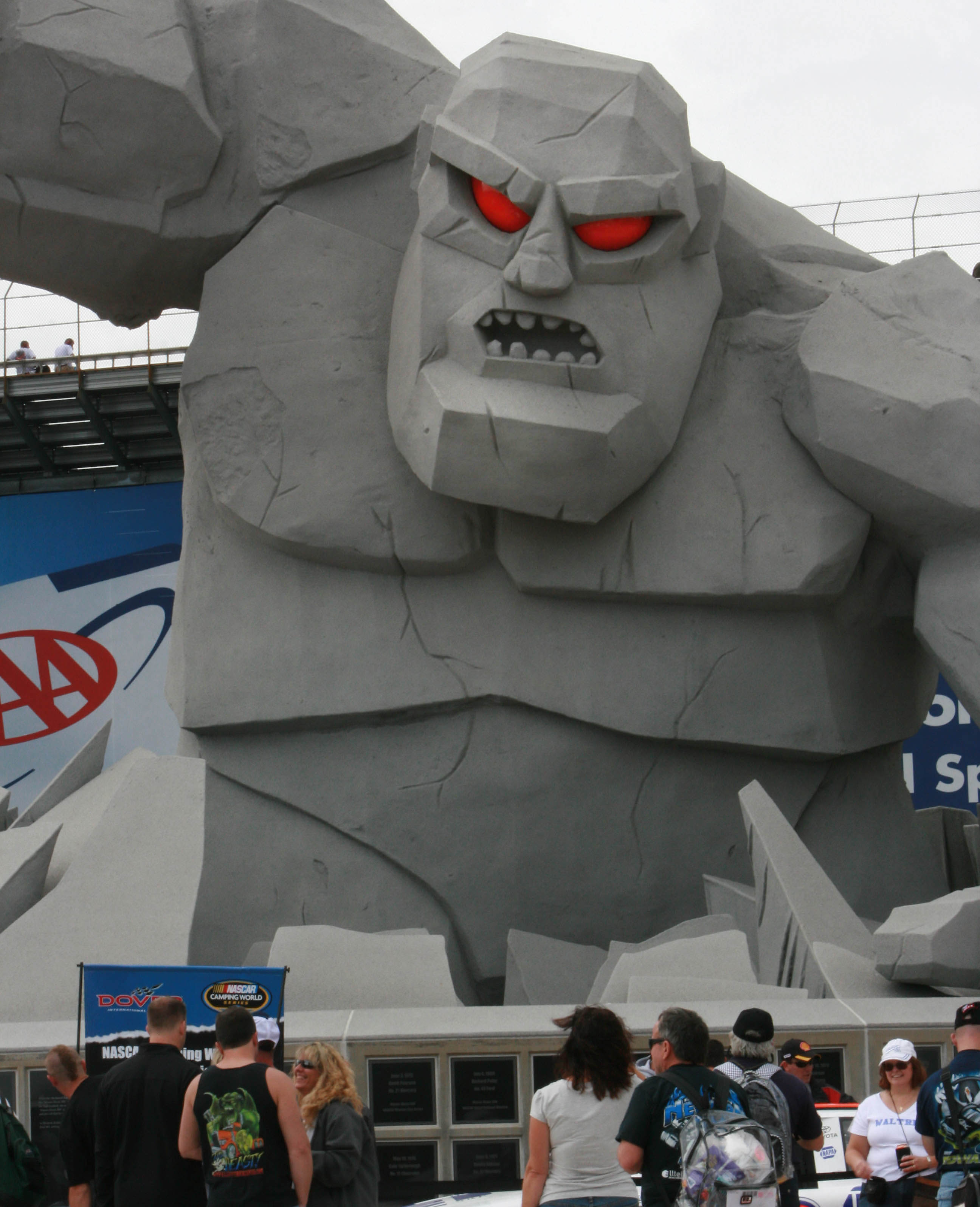 Monster with red eyes looms over speedway.