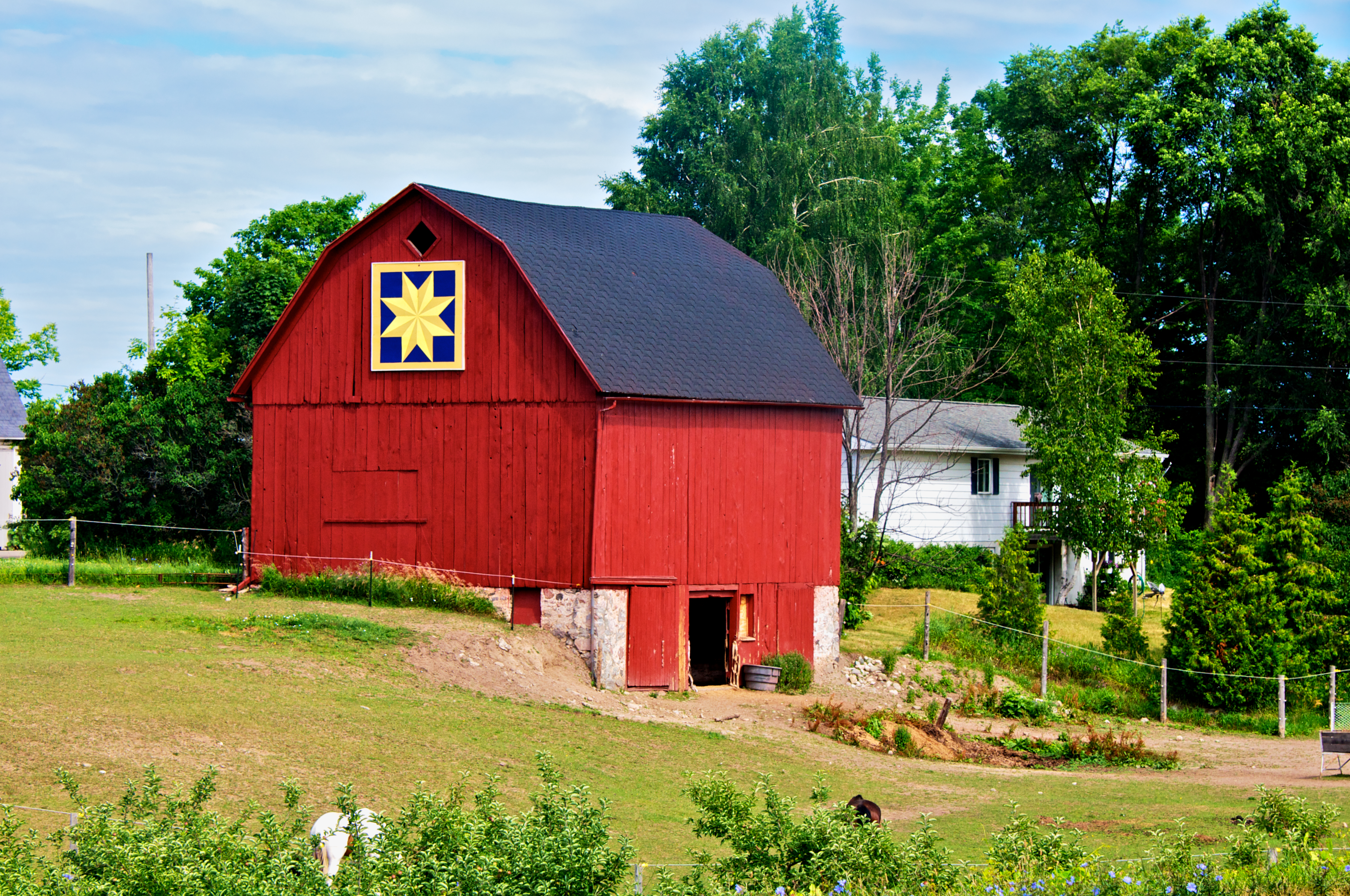 A bright red barn with a golden quilt.
