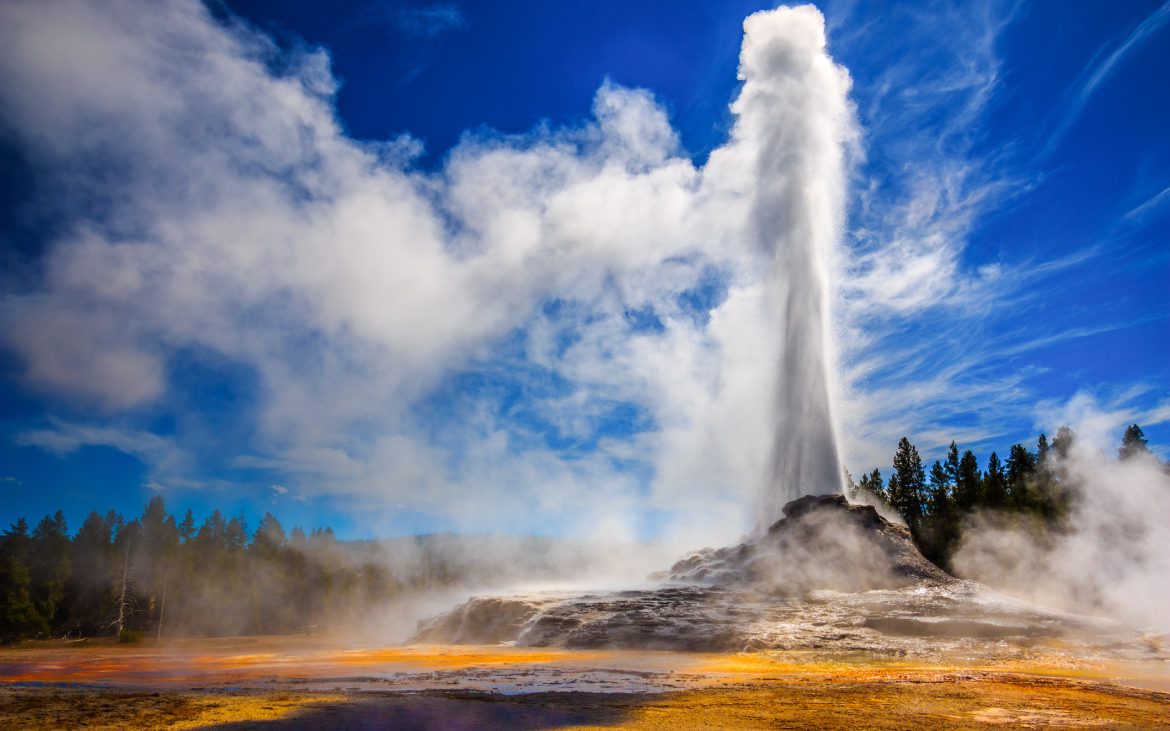 Castle Geyser erupting in Yellowstone in strong back light.