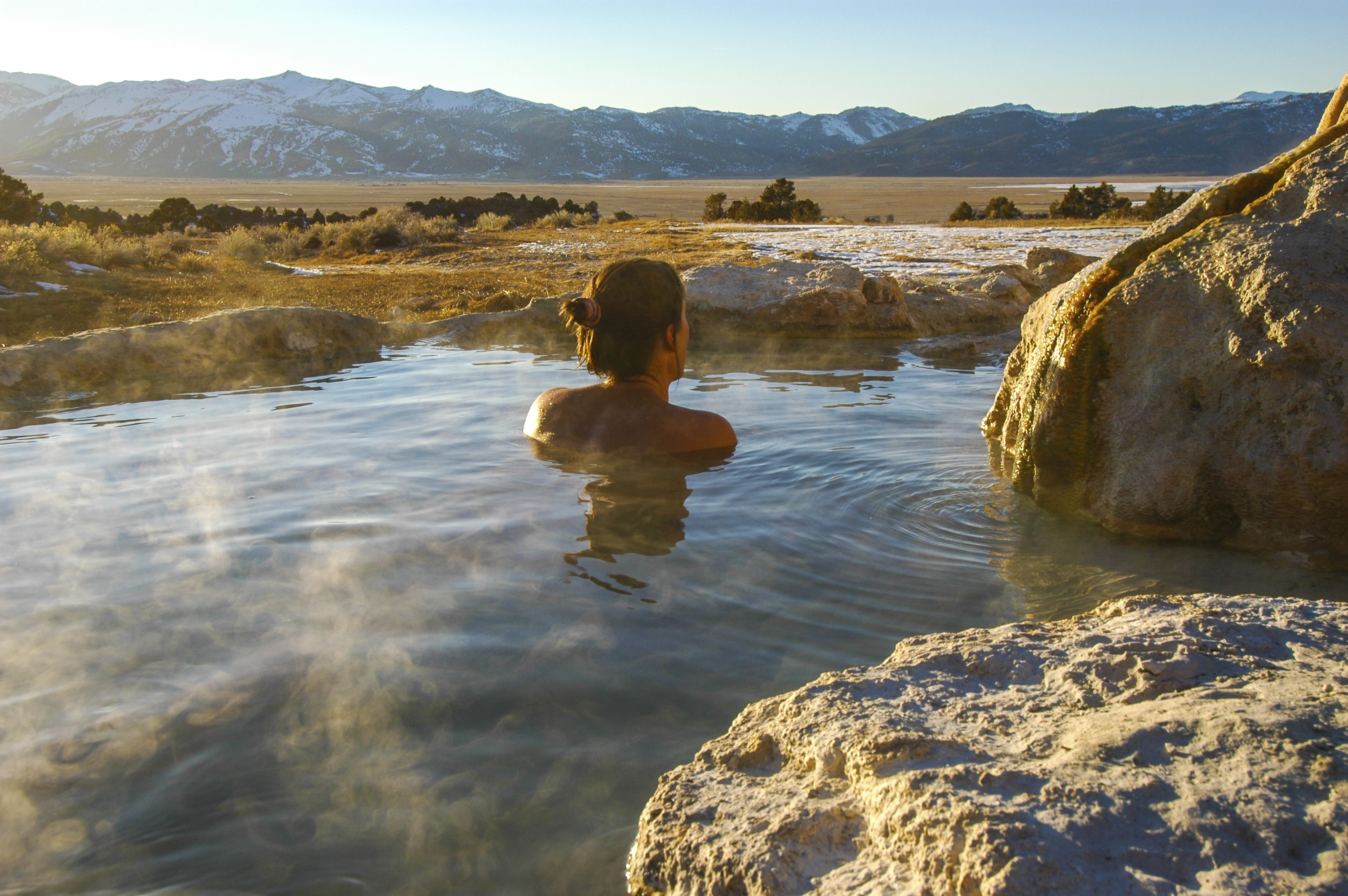 Woman soaking in a natural hot spring