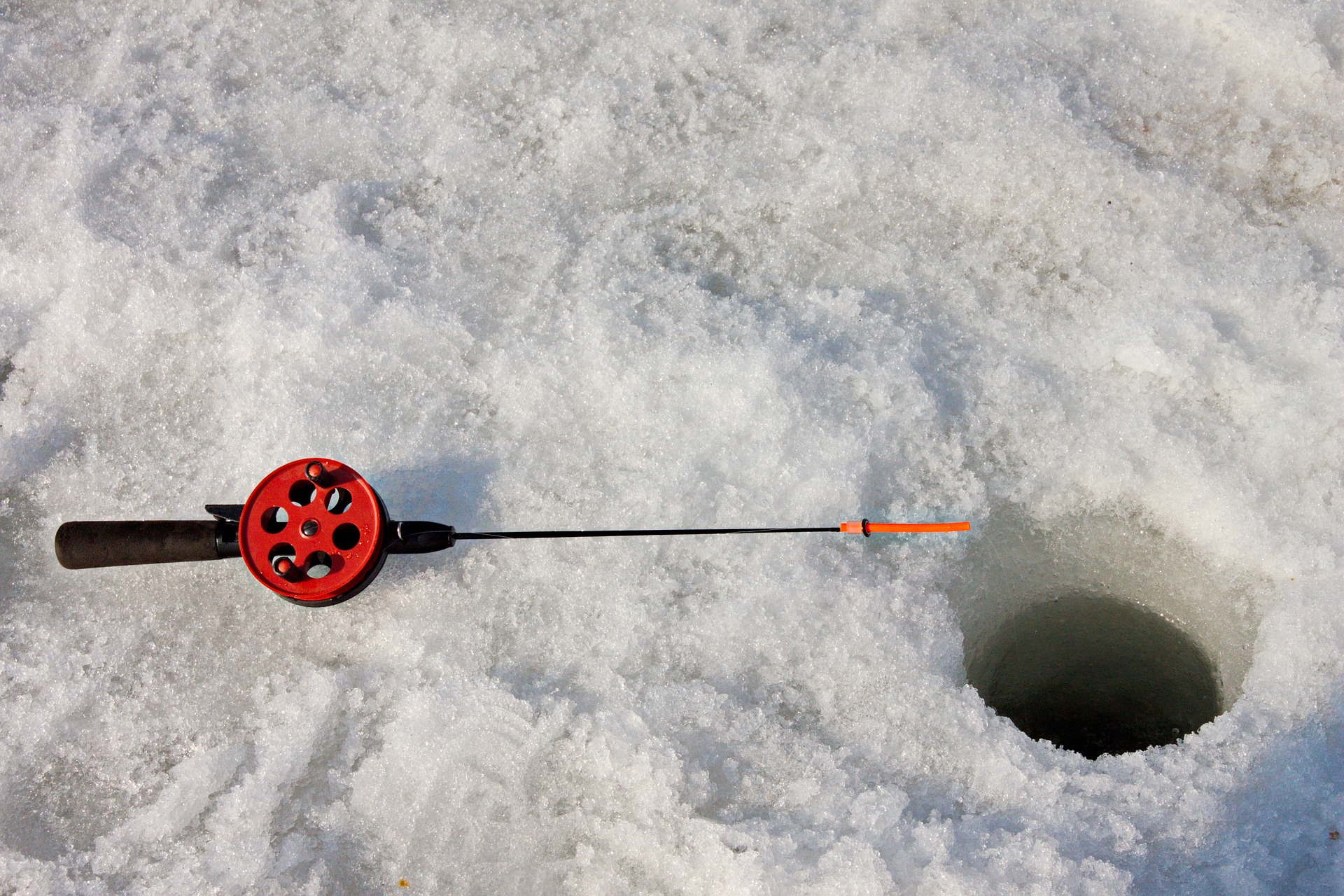 ice fishing pole near hole.