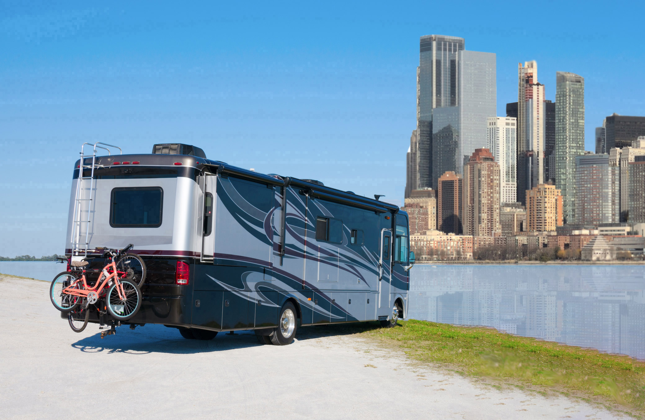RV on a body of water facing a large metropolis