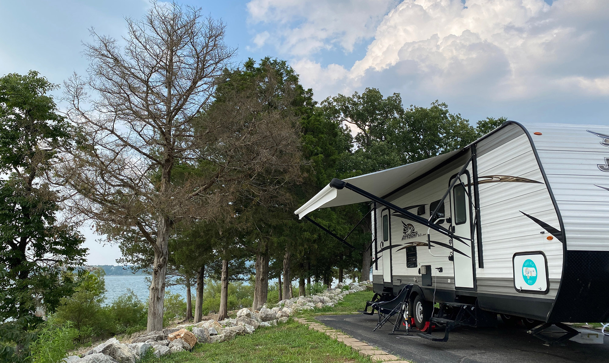 A travel trailer parked near a lake.