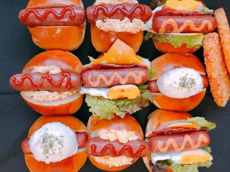 An array of hot dogs prepared with Japanese toppings.