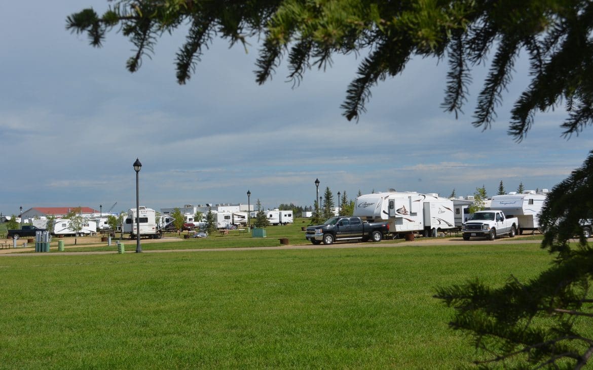 View of an RV park at the edge of a green expanse.