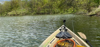 Bow of a kayak as it cuts through a pond or lake.