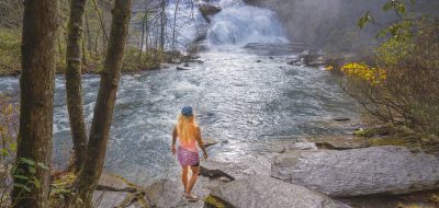 Woman relaxing by beautiful waterfall.