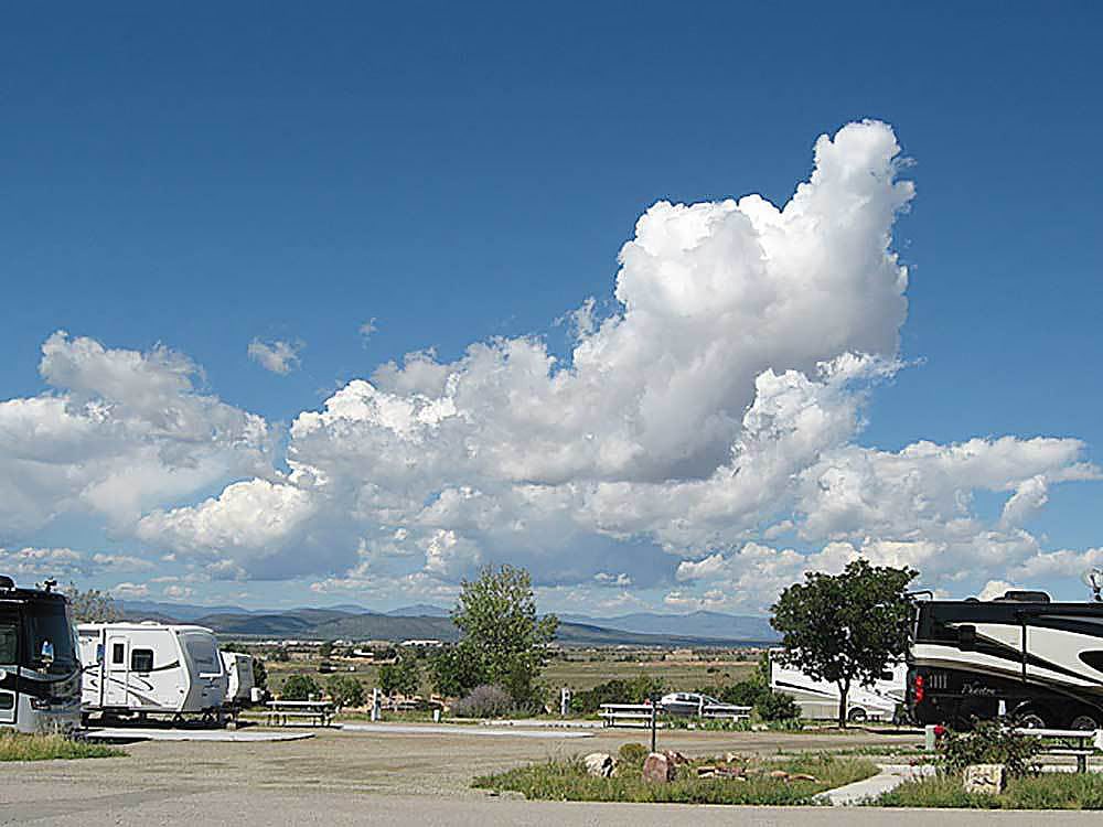 RVs parked under blue skies with a few puffy clouds.