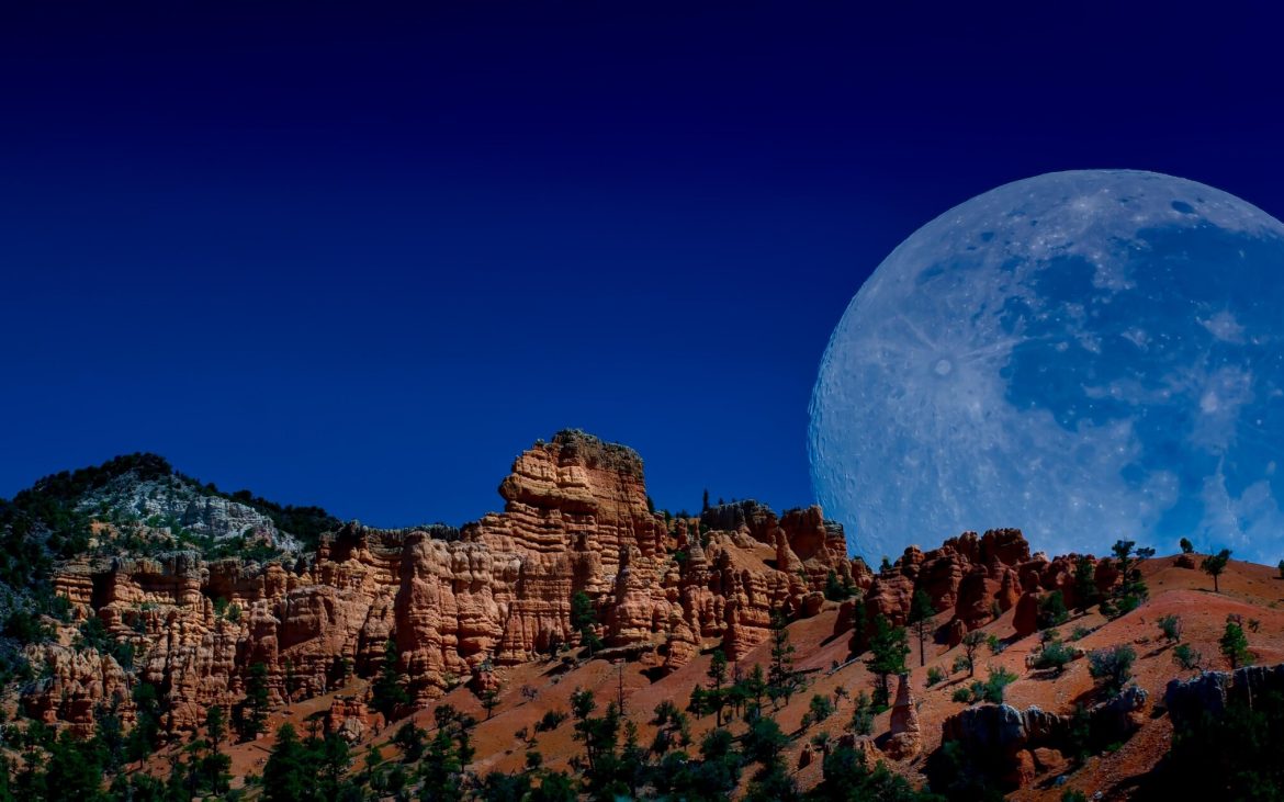 Bryce Valley Ranch — Moon rising over a rocky ridge.