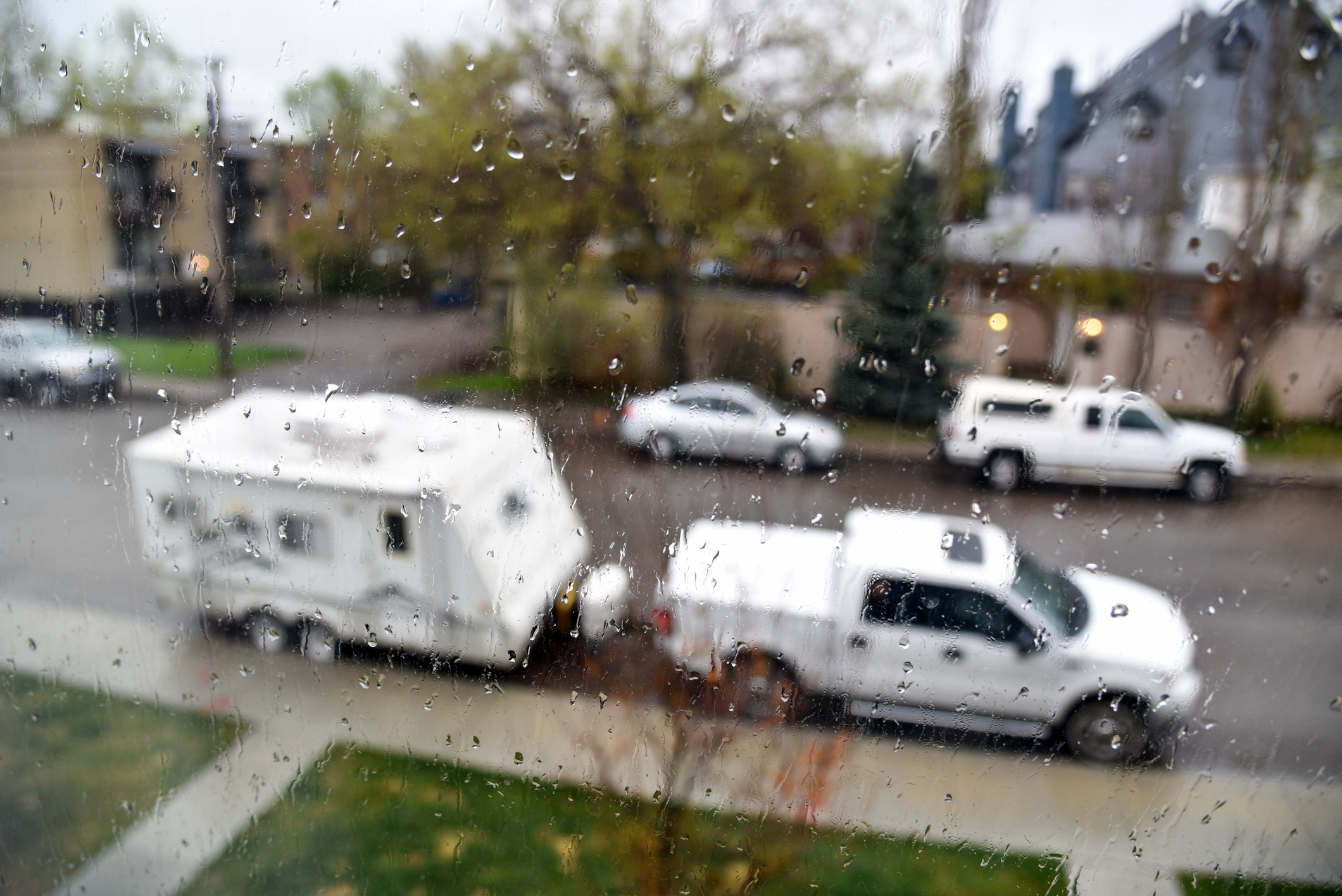 A travel trailer parked on a rainy street.