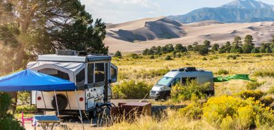 Travel trailer and Class B motorhome at a campsite