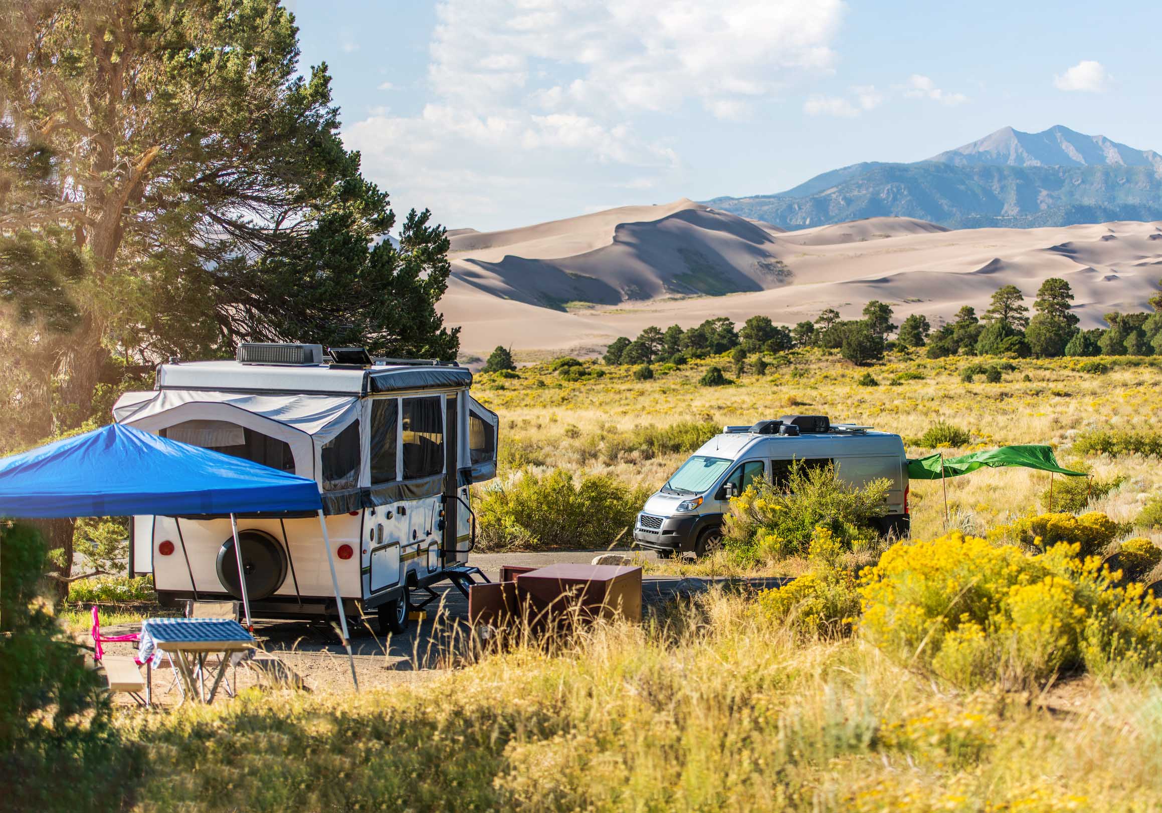 Travel trailer and Class B motorhome at a campsite