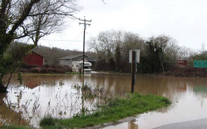 An RV on the edge of a flooded roadway.