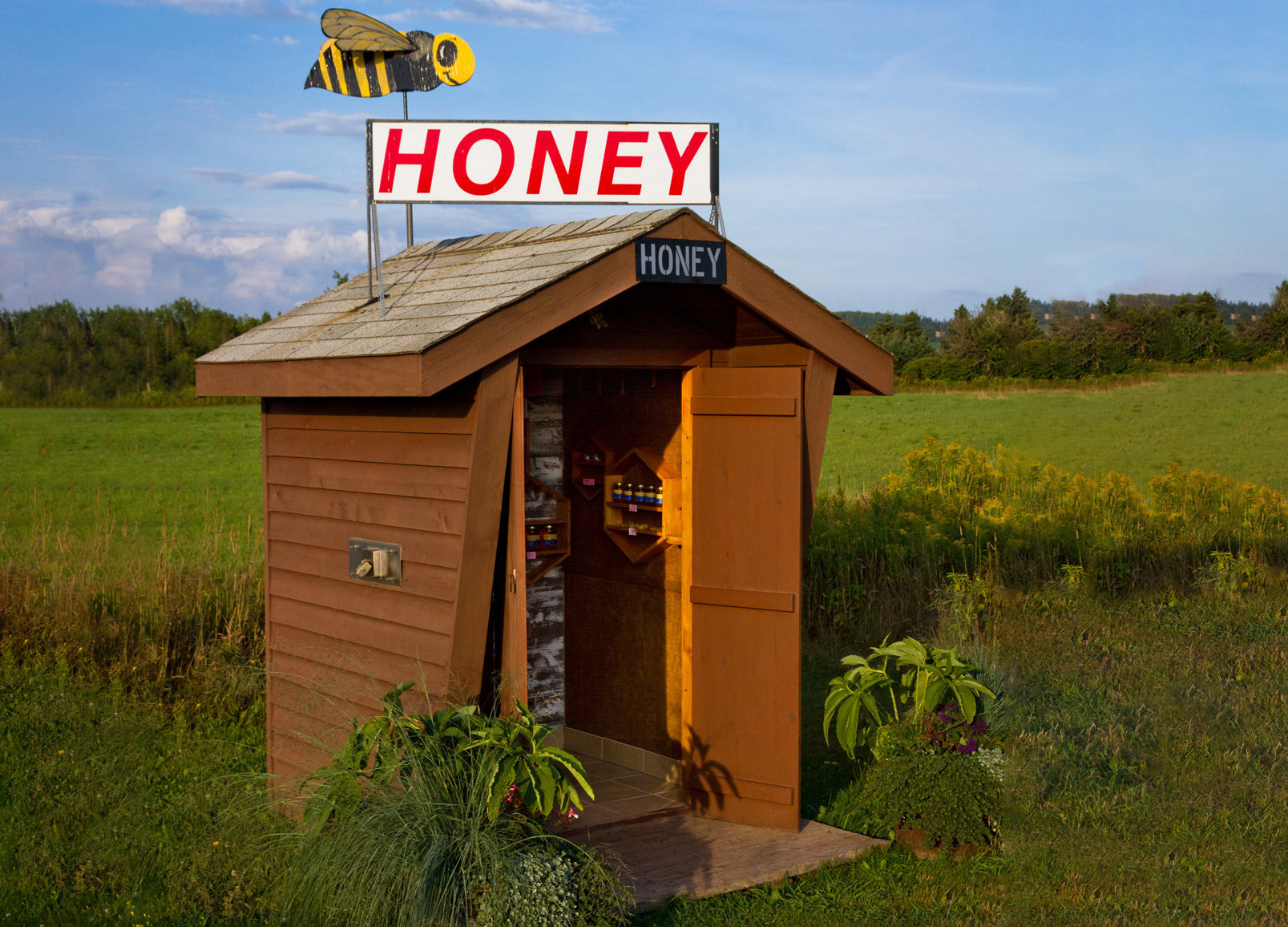 A honey hut in the middle of a field. 