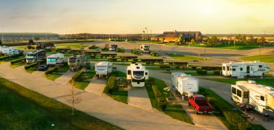 RVs in an RV campground under a sunny sky.