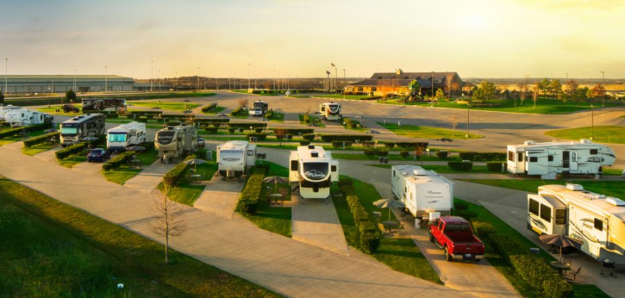 RVs in an RV campground under a sunny sky.