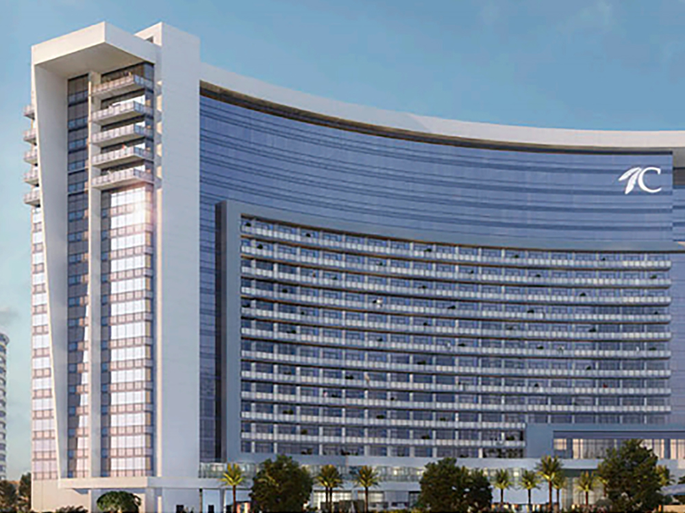 A curving hotel-resort building with glass windows under a blue sky.