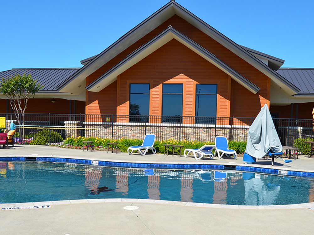 A kidney-shaped pool in the foreground, clubhouse in background.