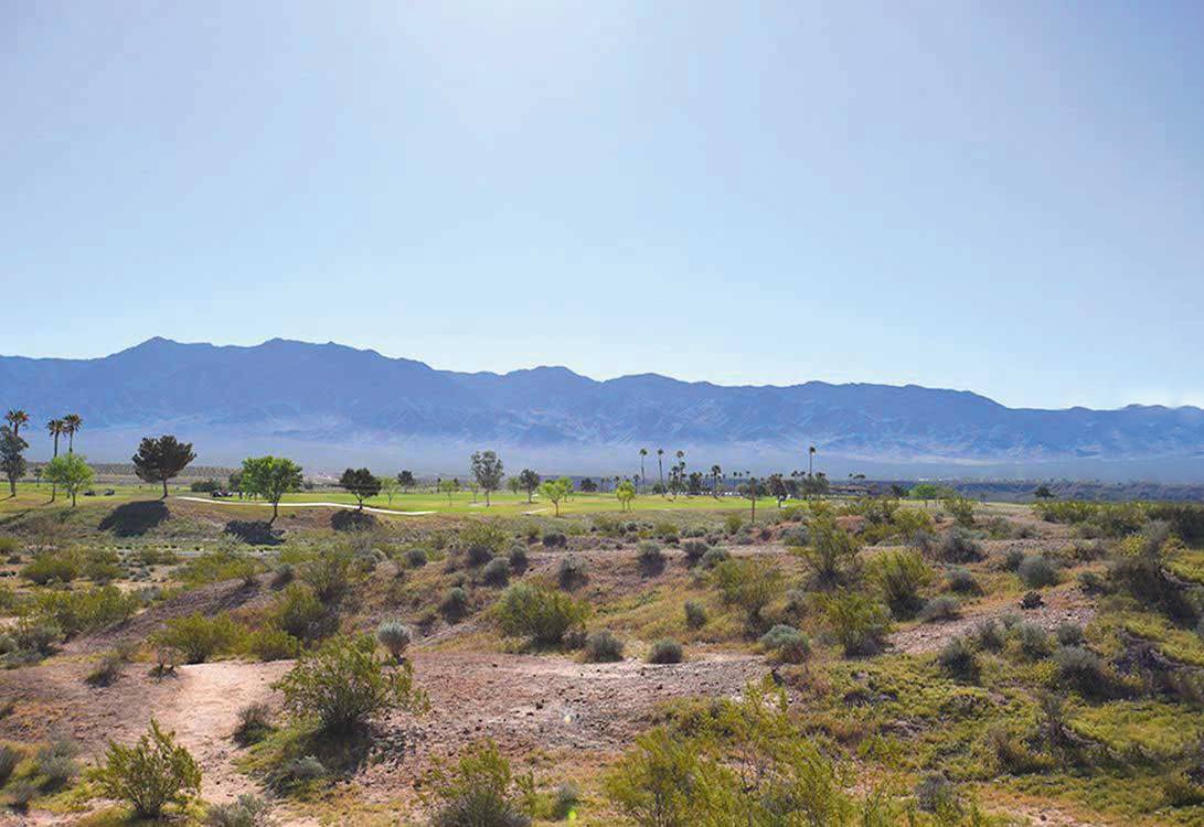 Golf course stretching across rugged desert landscape.