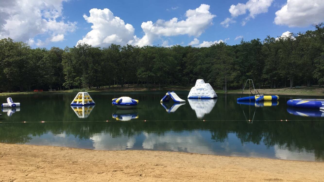 Floating play structures on a smooth lake.