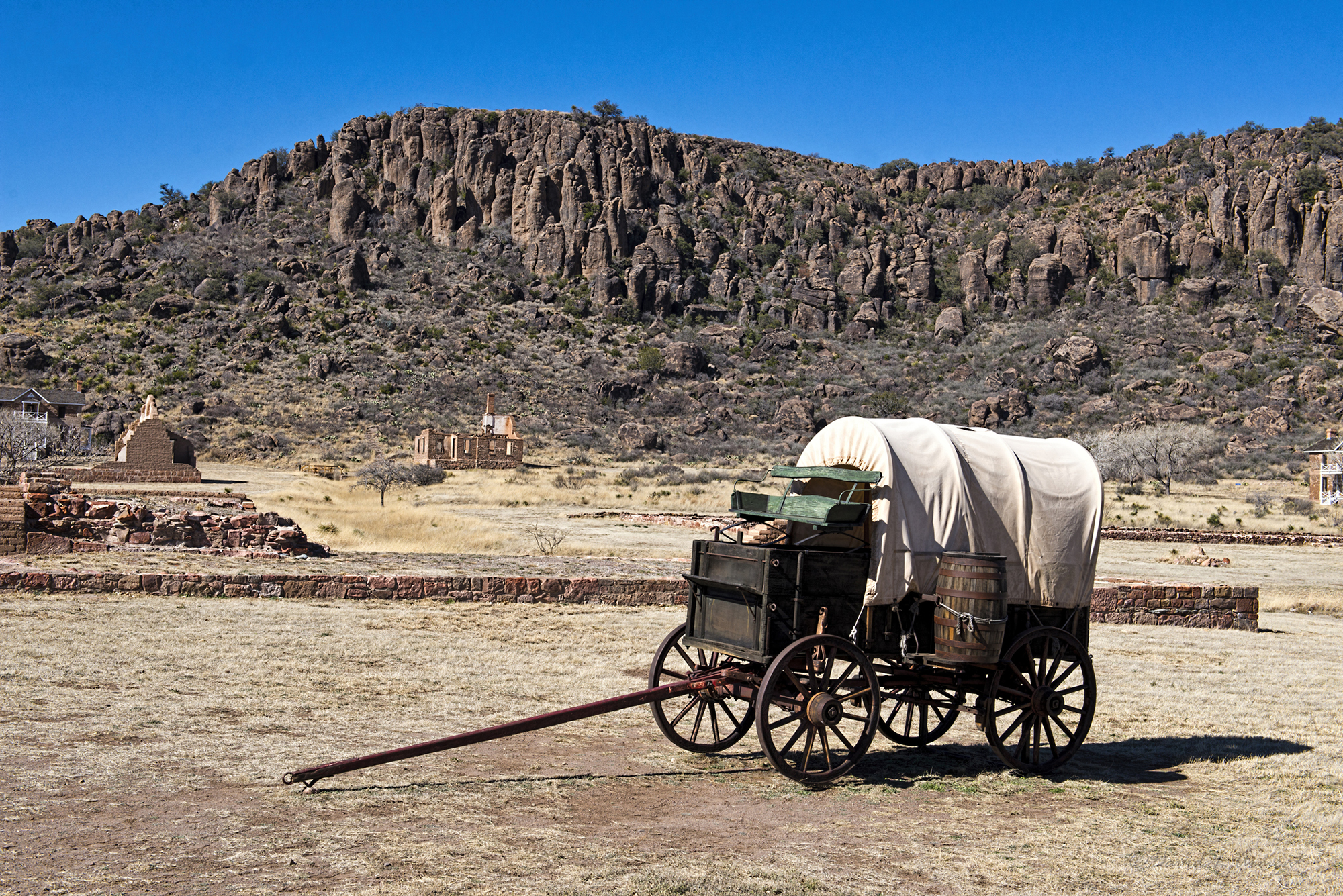 Covered wagon with stark rocks in the background.