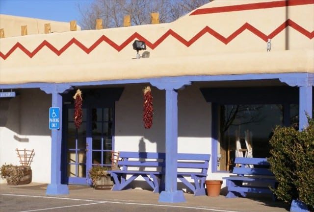 A breezeway with wooden supports painted blue.