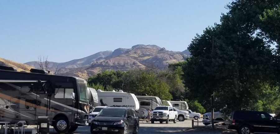 RVs in a park with mountains looming in the background.