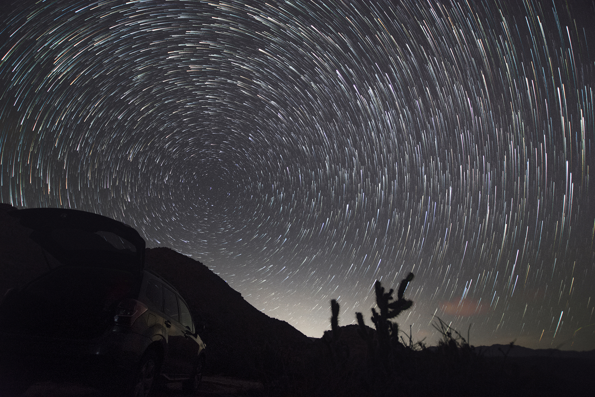 Time laps shot of stars circling the sky over the desert. 