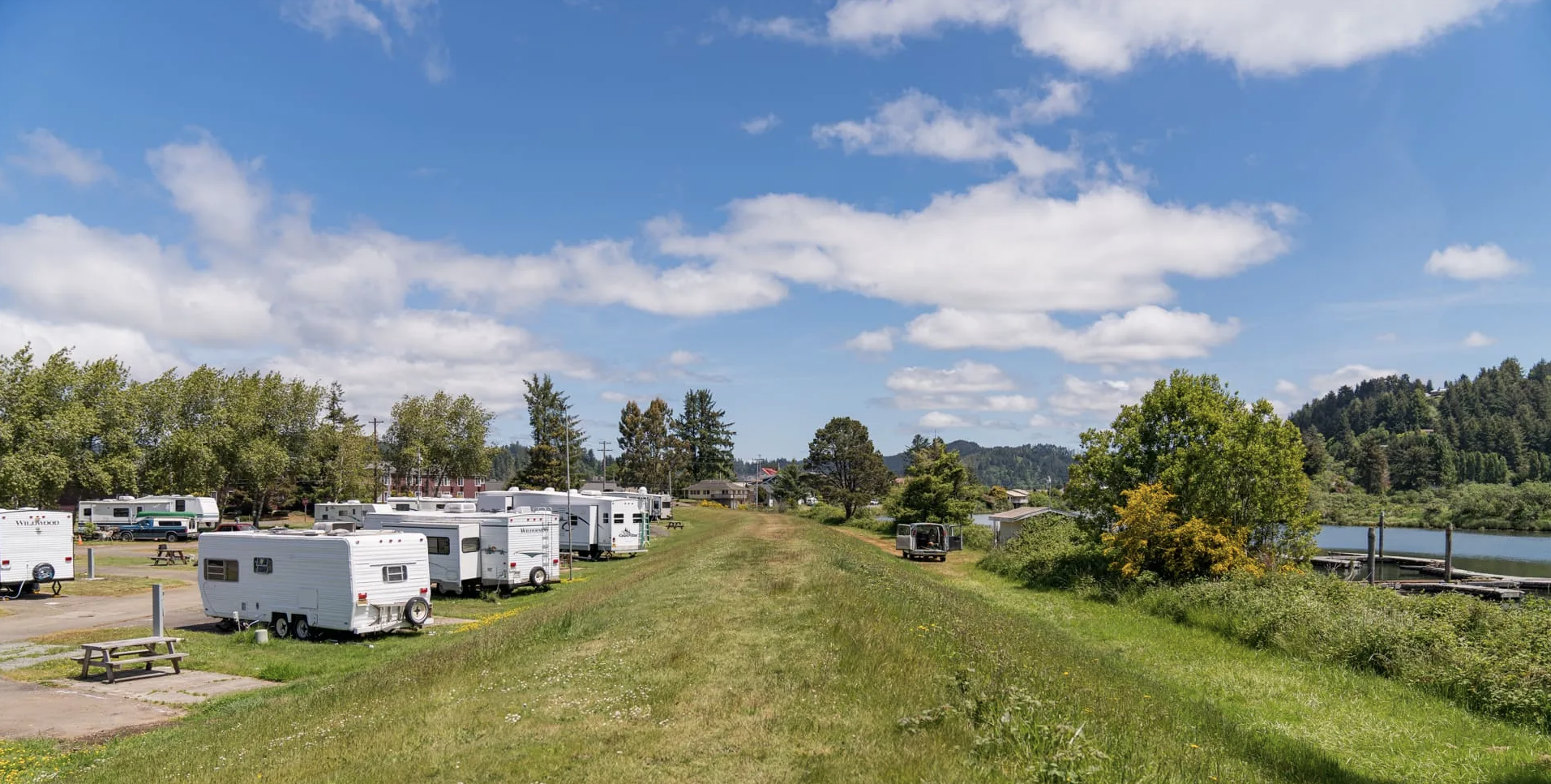 RVs parked on the banks of a straight Levy.