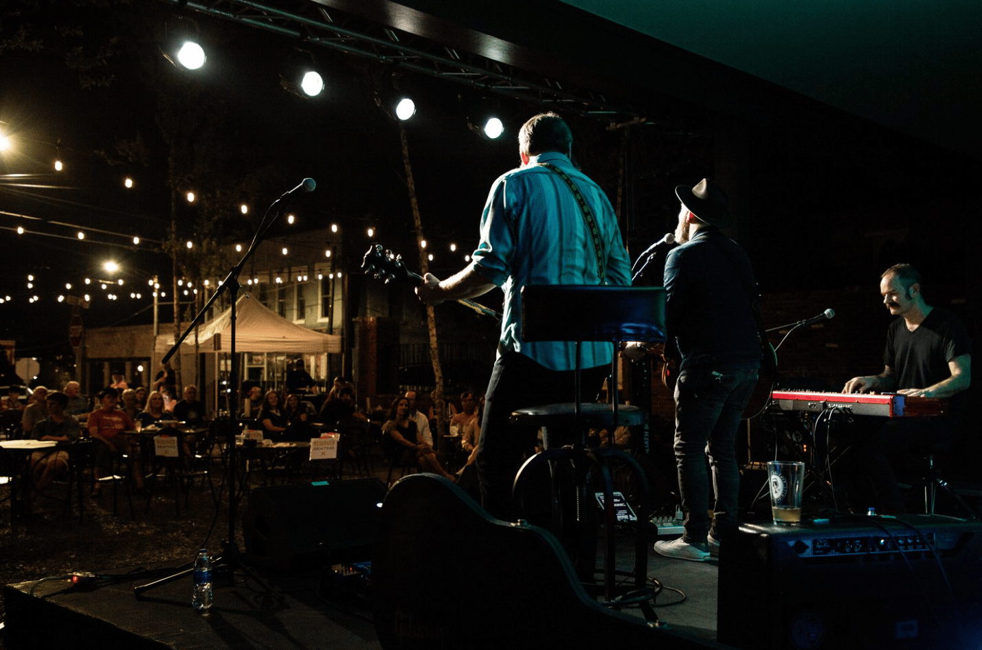 A musical group performs in a dark theater.