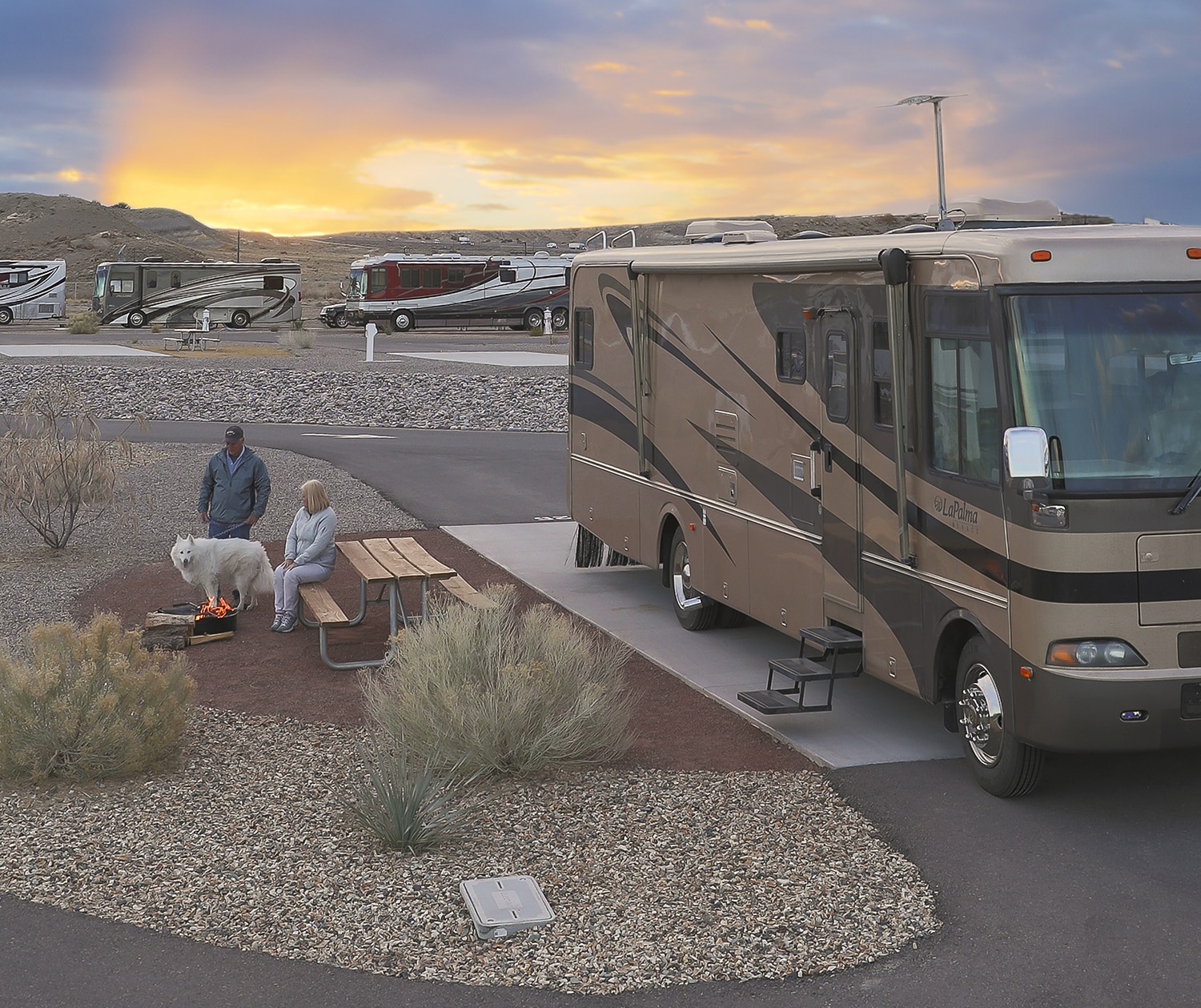 RV travelers relaxing outside of their motorhome in an ample RV space.