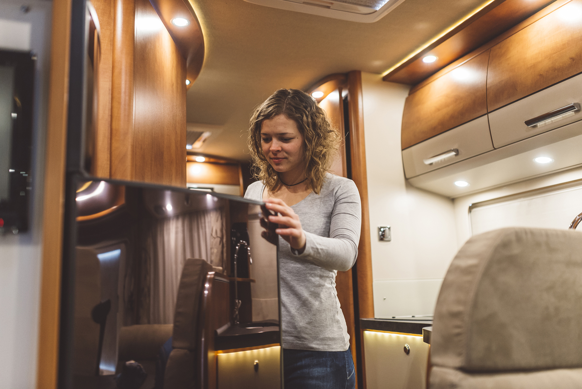 Girl opening a fridge in a luxury motorhome