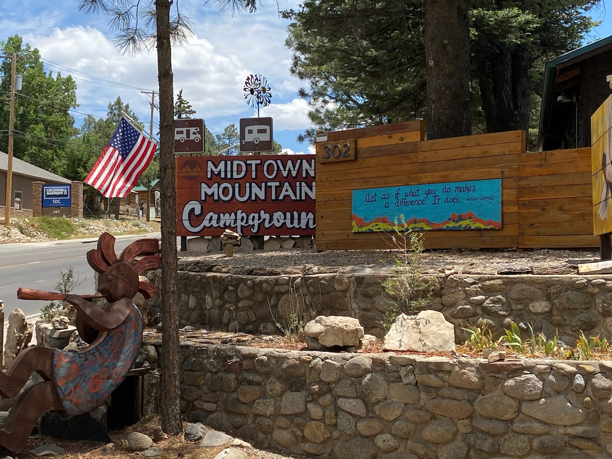 A campground entrance with sculpture of Native American playing flute.