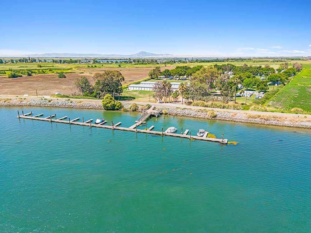 Aerial shot of a dock on emerald waters.