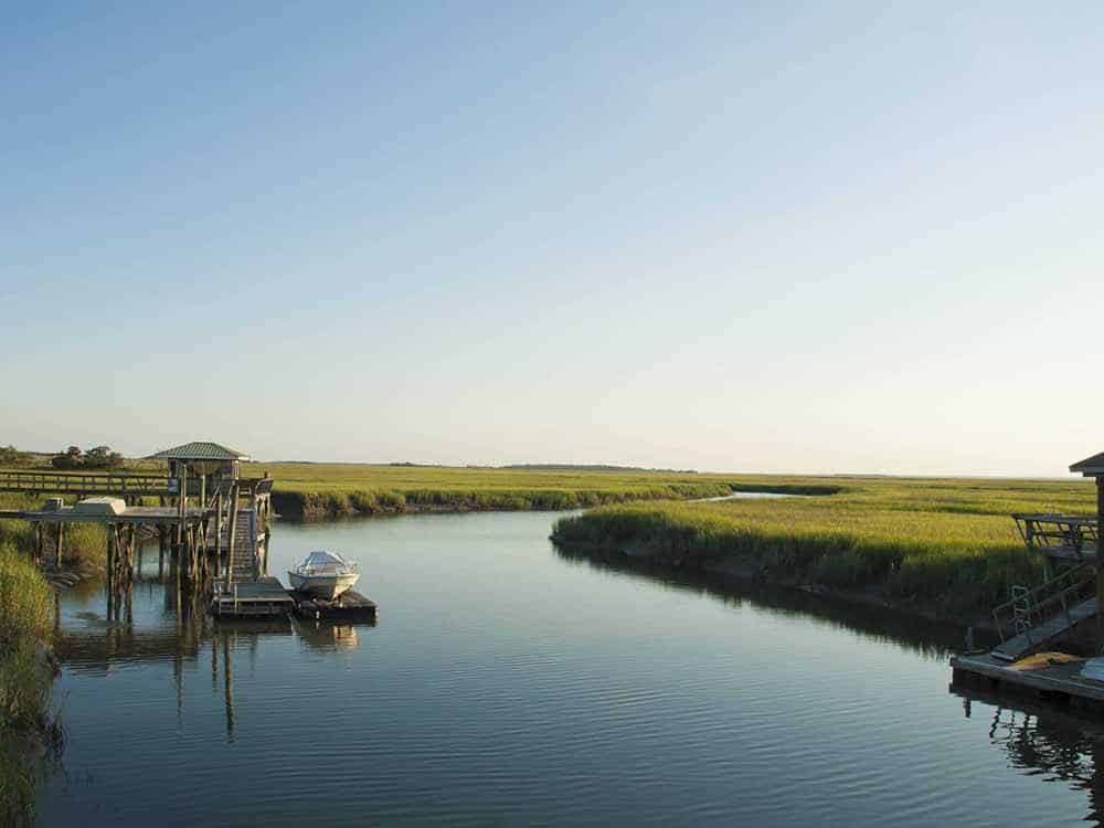 Dock and waterway flanked by grassy fields.