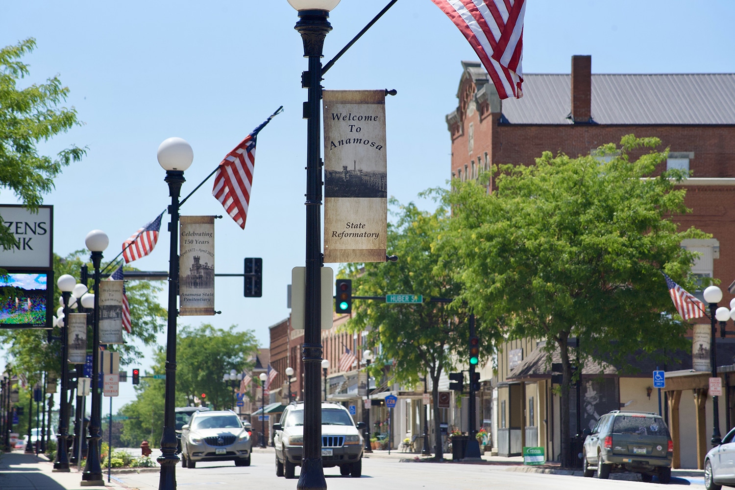A smalltown street with lightposts festooned with American flags.