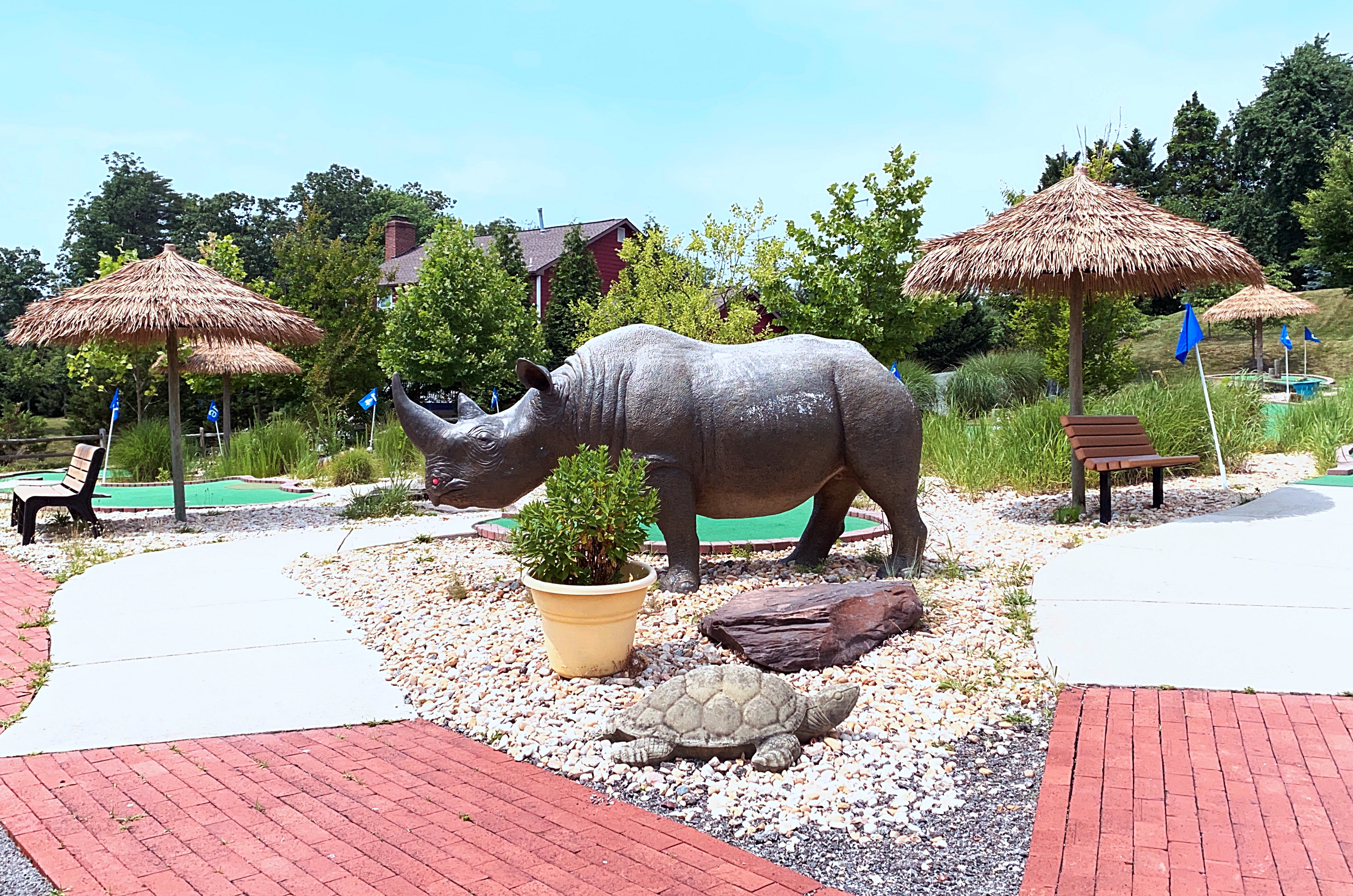 Miniature golf course with statue of rhino. 