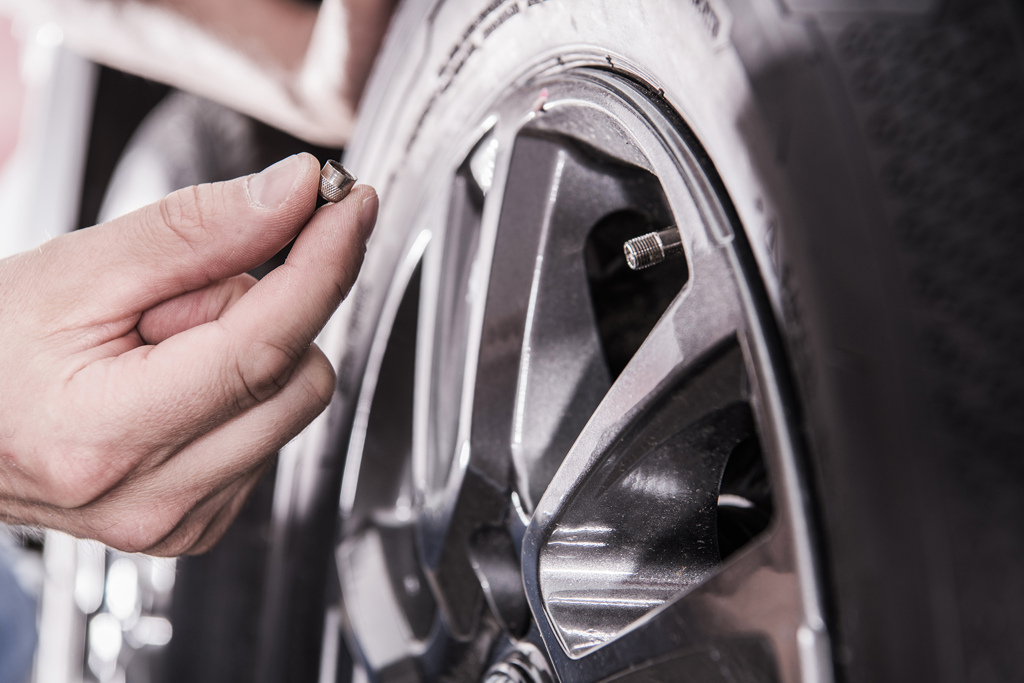 Caucasian Men Checking RV Recreational Vehicle Tire Pressure. Closeup Photo.