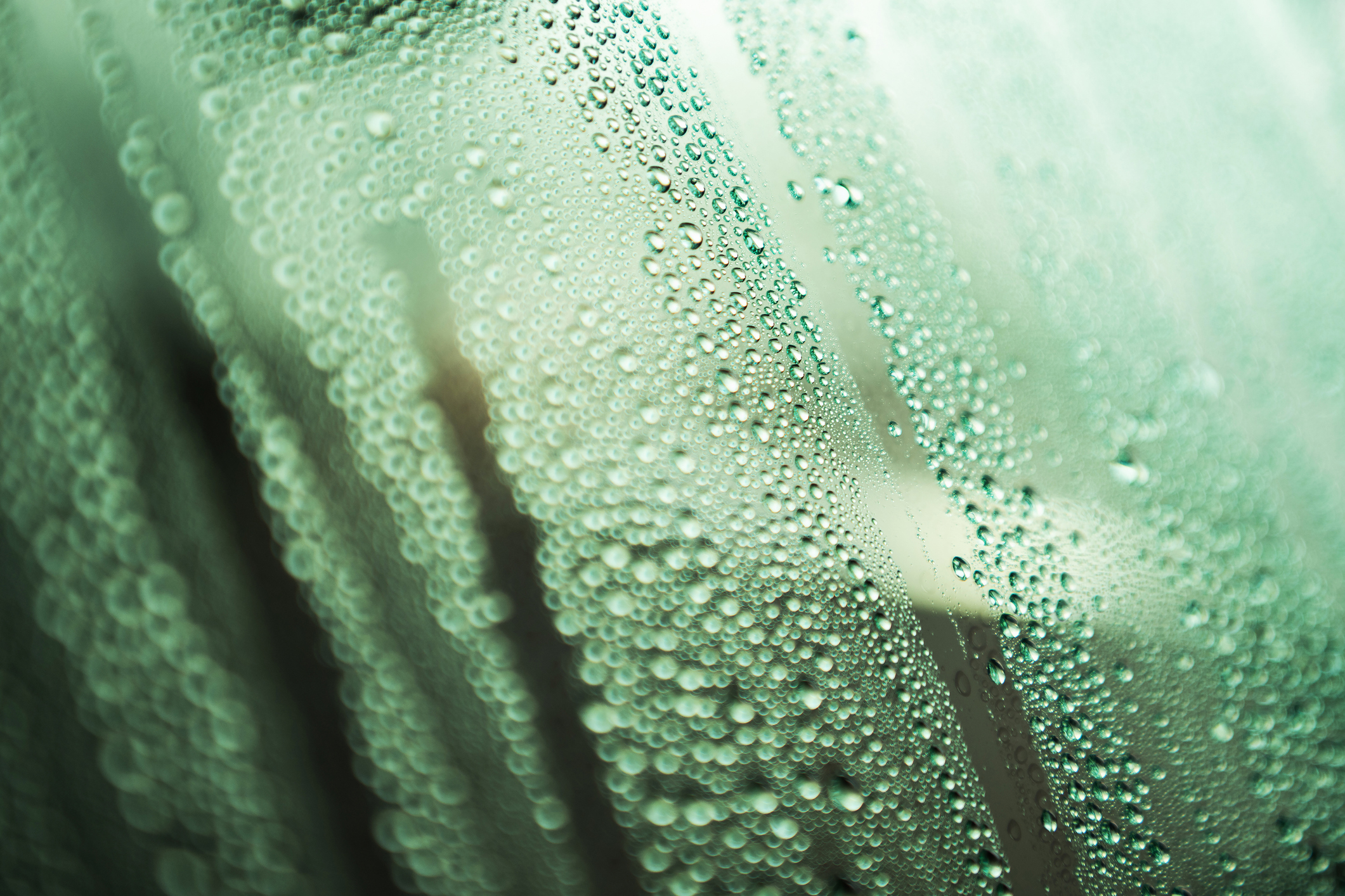 RV window with raindrops gathering.