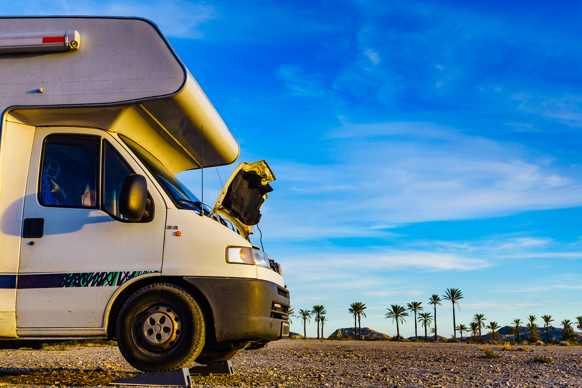 Broken down camper vehicle on road.