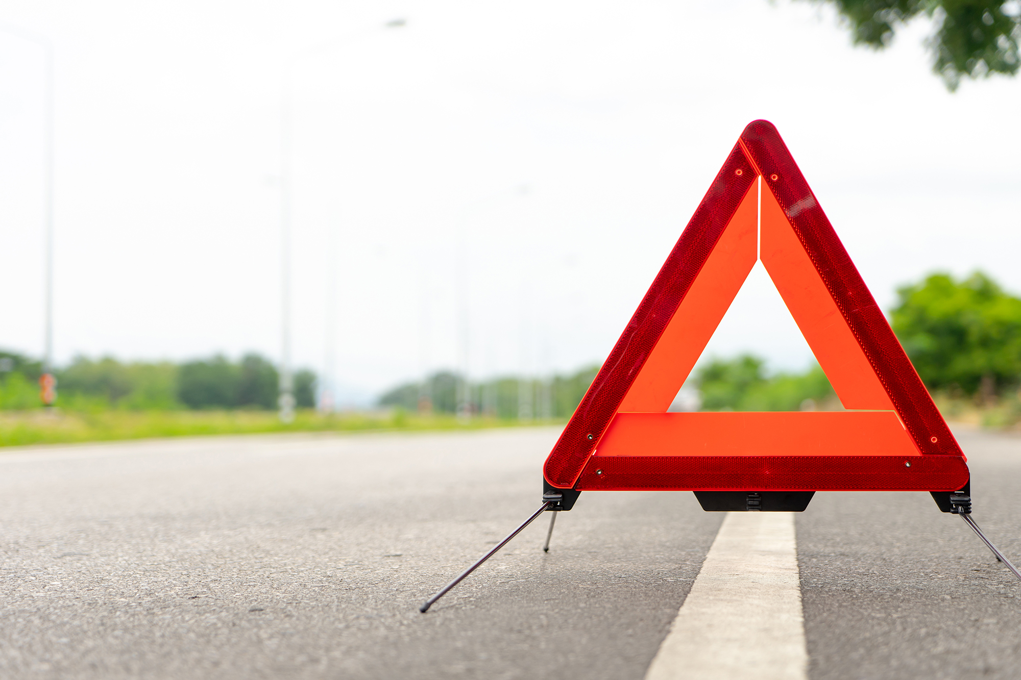 breakdown triangle stands alongside the road. Car broke down sign on road concept.