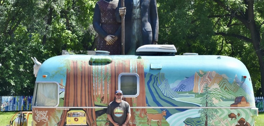 Heartland of America — Colorful Airstream trailer with towering statue in background.