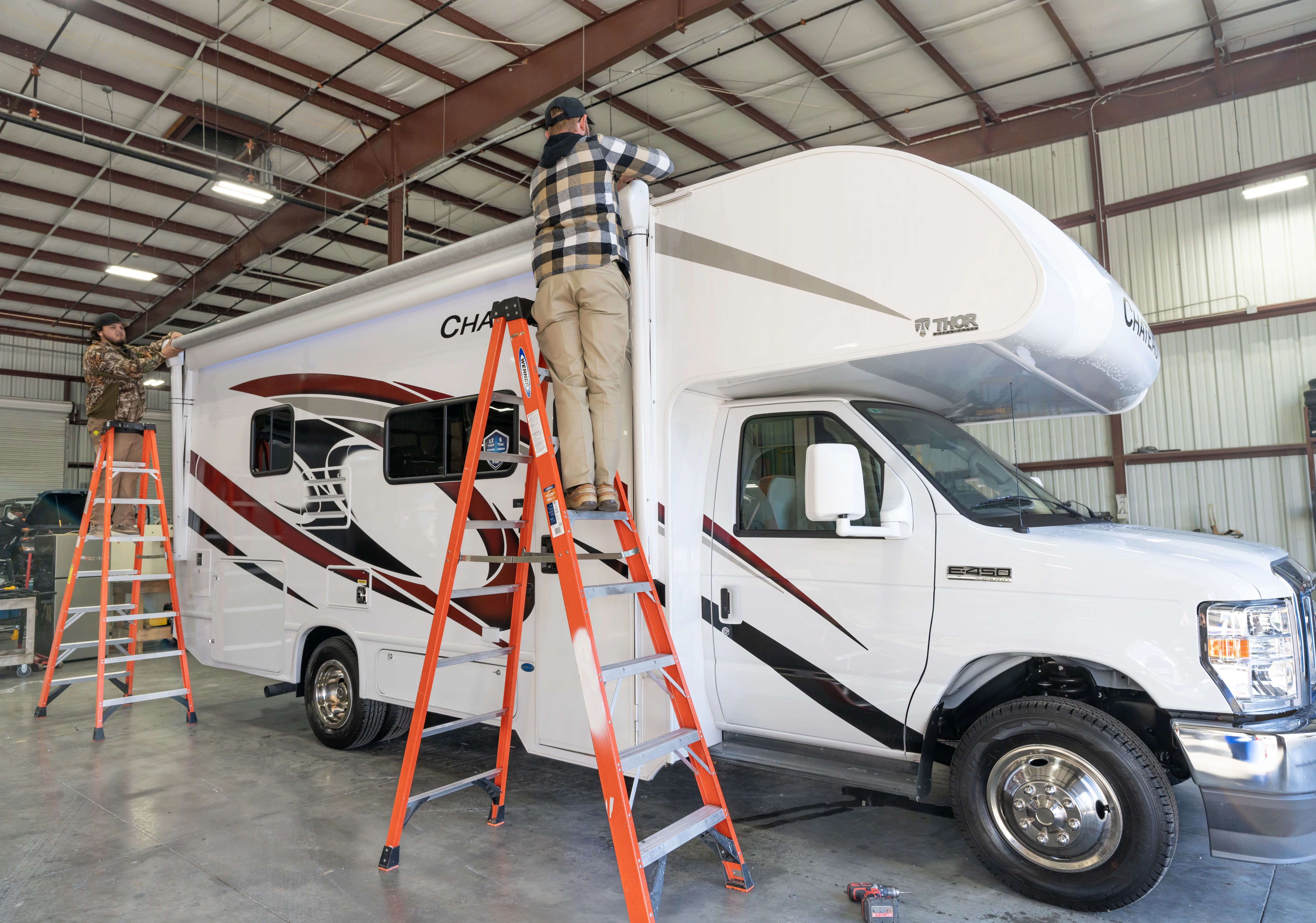 Technician performing awning care on a Class C motorhome.